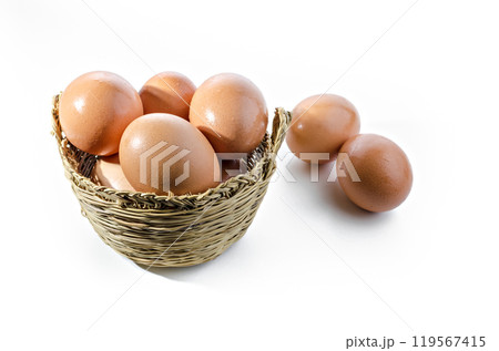 Fresh eggs inside a wicker basket on white background. Copy space 119567415