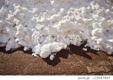 A thick layer of fresh snow covers a brick road surface during the winter season A thick layer of fresh snow covers a brick road surface during the winter season 119567607