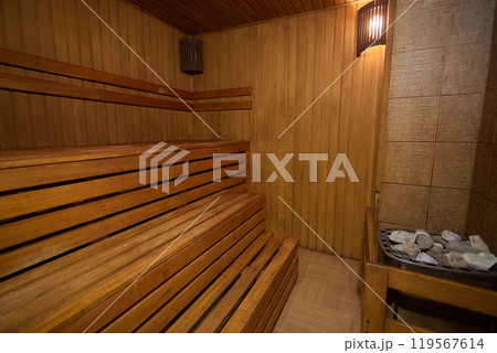 A hardwood sauna with a plank ceiling, brick wall, and stairs A hardwood sauna with a plank ceiling, brick wall, and stairs 119567614
