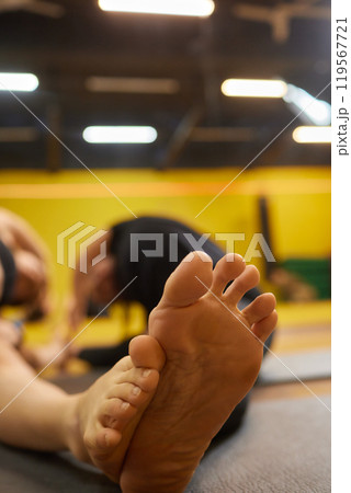 A woman is bending her knee in a gym to stretch her legs A woman is bending her knee in a gym to stretch her legs 119567721