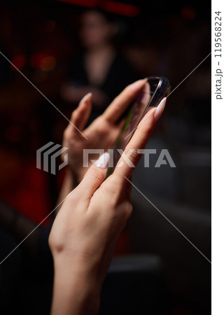 a woman is sitting at a table looking at her cell phone 119568224