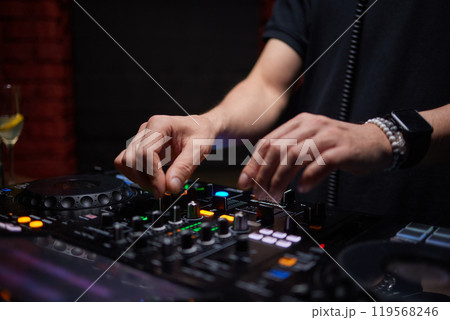 control DJ for mixing music with blurred people dancing at party in nightclub. control DJ for mixing music with blurred people dancing at party in nightclub. 119568246