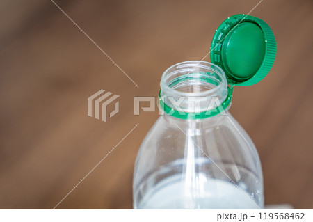 Stationary plastic cap on a PET bottle. The new design means the cap remains attached to the bottle after opening, making the entire package easier to collect and recycle 119568462