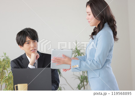 仕事の報告をする部下と困っている上司_1 119568895