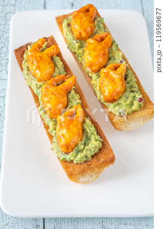 Guacamole toasts with crab claws 119569677