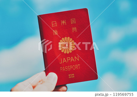 パスポートを持つ人の手元と青空背景 パスポートを持つ人の手元と青空背景 119569755