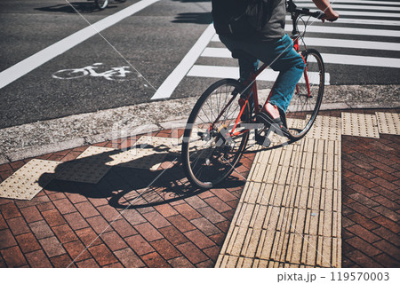 横断歩道の手前で停車する自転車に乗る人 119570003