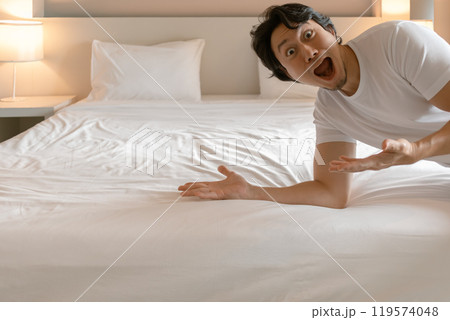 Funny wow face man feeling amazing and present the bedroom of hotel. Funny wow face man feeling amazing and present the bedroom of hotel. 119574048