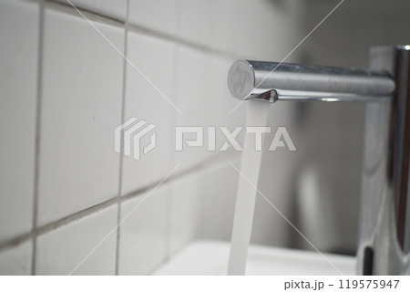 Fresh water is flowing gracefully from a sleek, shiny chrome faucet in a cozy kitchen setting, Fresh water is flowing gracefully from a sleek, shiny chrome faucet in a cozy kitchen setting, 119575947