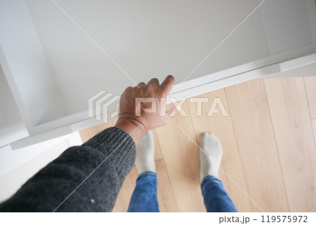 An individual is extending their hand towards an empty drawer located in a contemporary interior An individual is extending their hand towards an empty drawer located in a contemporary interior 119575972