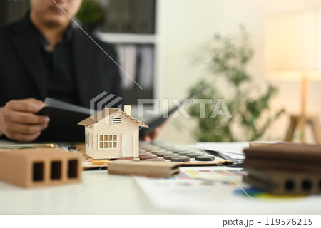 A small house model and color swatches on architect desk. Home improvement concept A small house model and color swatches on architect desk. Home improvement concept 119576215