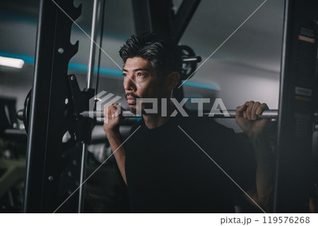 スポーツジムで下半身を鍛える40代男性 スポーツジムで下半身を鍛える40代男性 119576268