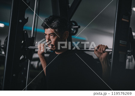 スポーツジムで下半身を鍛える40代男性 スポーツジムで下半身を鍛える40代男性 119576269