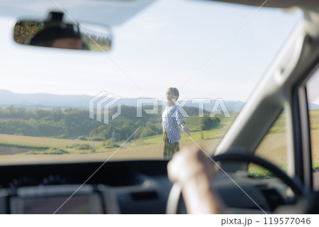 車の外を歩く若い女性 119577046