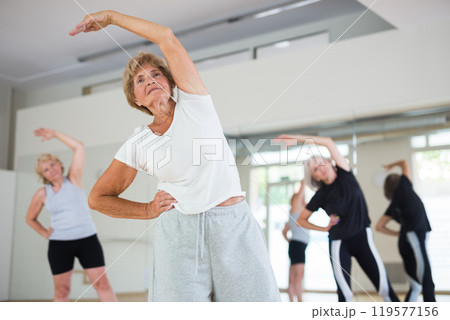 Portrait of mature energetic woman practicing active dancing at a group lesson Portrait of mature energetic woman practicing active dancing at a group lesson 119577156