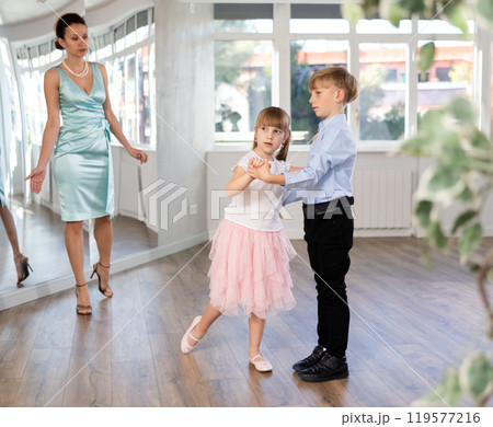 Preteen boy and girl refining slow foxtrot technique in dance hall 119577216