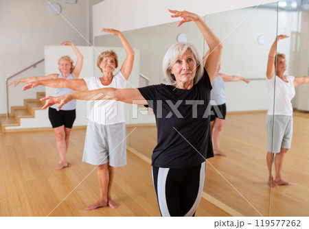 Group of elderly women standing in the 3rd position of the ballet stand Group of elderly women standing in the 3rd position of the ballet stand 119577262