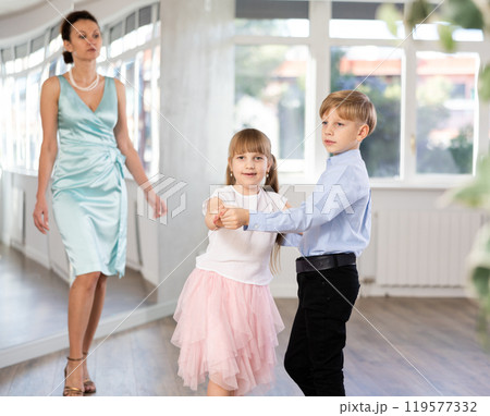Boy and girl in pair train to dance contemporary vigorous waltz during classes. 119577332