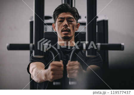 スポーツジムで上半身を鍛える40代男性 スポーツジムで上半身を鍛える40代男性 119577437