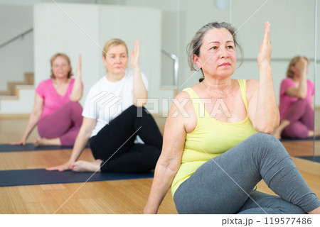 Active elderly woman practicing yoga at group 119577486
