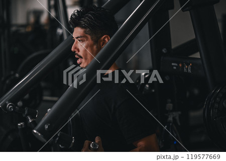 ジムで上半身をマシンを使って鍛える男性 ジムで上半身をマシンを使って鍛える男性 119577669