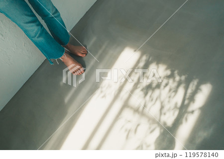 裸足の女性と窓明かり 119578140