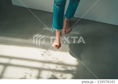 裸足の女性と窓明かり 119578141