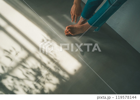 裸足の女性と窓明かり 119578144
