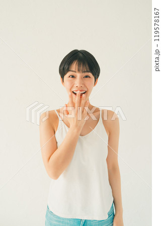 白い背景の前でキャミソール姿の若い女性の驚喜 白い背景の前でキャミソール姿の若い女性の驚喜 119578167