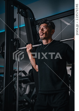 ジムで筋力トレーニングをする40代男性 ジムで筋力トレーニングをする40代男性 119578346
