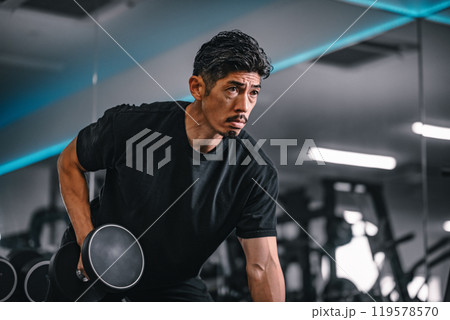 ジムでマシンを使ってトレーニングをする男性 119578570