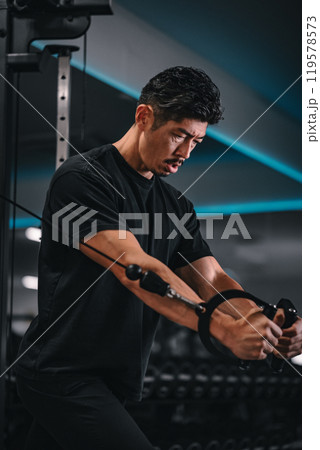 ジムでマシンを使ってトレーニングをする男性 ジムでマシンを使ってトレーニングをする男性 119578573