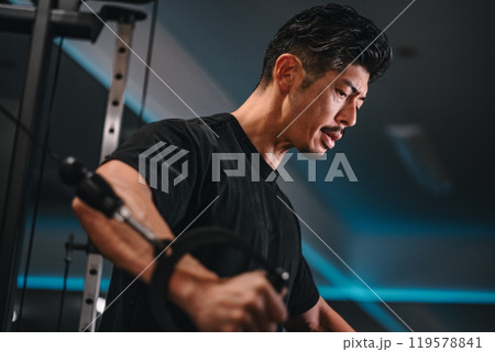 ジムでマシンを使ってトレーニングをする男性 119578841