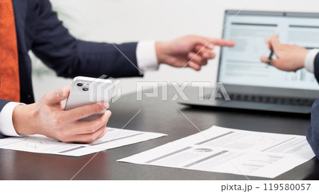 ミーティングでスマホを使うビジネスマンの手元 ミーティングでスマホを使うビジネスマンの手元 119580057