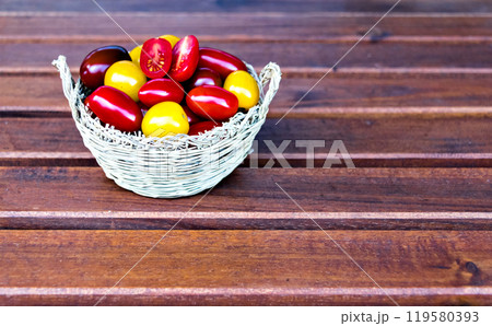 Fresh and colorful cherry tomatoes on dark brown wooden background Fresh and colorful cherry tomatoes on dark brown wooden background 119580393