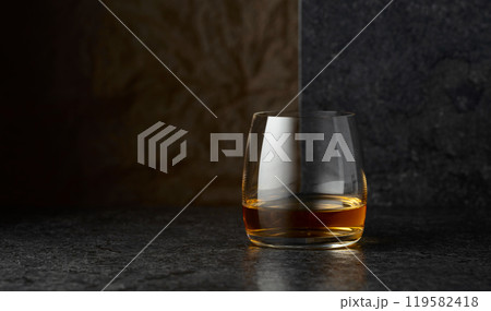 Glass of whiskey on a black table. Glass of whiskey on a black table. 119582418