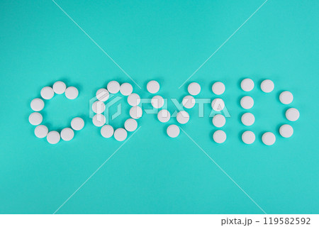 White pills in form word coronavirus on blue background 119582592