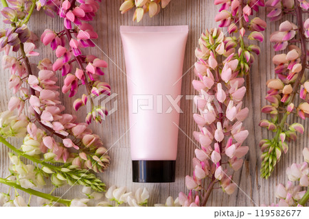 cosmetic moisturizer cream bottle tube and lupine flowers a lot. facial cream, shampoo, gel, skincare, sunblock or sunscreen. pink black blank tube, template mockup 119582677