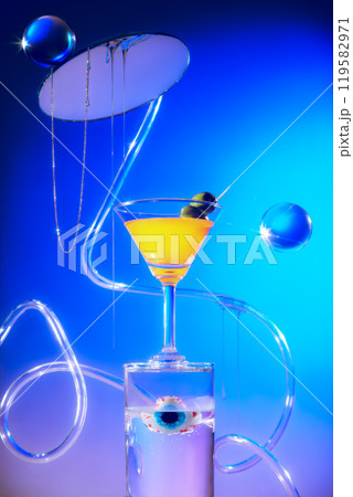 Front view image template shows a yellow cocktail with olives on a transparent circular platform with a fake eye inside; above is a glass ball and glass suspended in a blue-purple gradient backdrop. Front view image template shows a yellow cocktail with olives on a transparent circular platform with a fake eye inside; above is a glass ball and glass suspended in a blue-purple gradient backdrop. 119582971