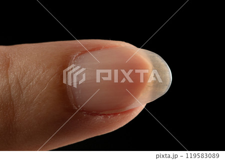 Clean normal long fingernail without color or coating on nail. Long clean fingernail to show texture detail of uneven nail and scratch skin, black background isolated Clean normal long fingernail without color or coating on nail. Long clean fingernail to show texture detail of uneven nail and scratch skin, black background isolated 119583089