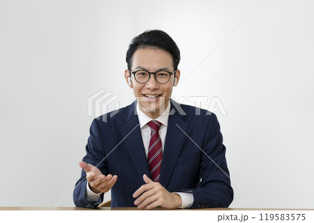 カメラ目線で話すイヤホンをしたアラフォーのビジネスマン カメラ目線で話すイヤホンをしたアラフォーのビジネスマン 119583575