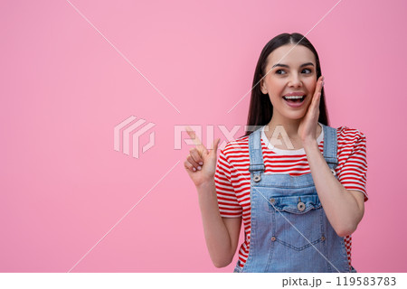 Waist up of a smiling young dark-haired woman in striped tshirt on pink background Waist up of a smiling young dark-haired woman in striped tshirt on pink background 119583783