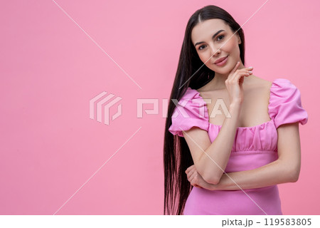 Pretty young long-haired woman in pink dress looking dreamy 119583805
