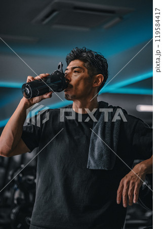 ジムで水分補給する男性 ジムで水分補給する男性 119584417