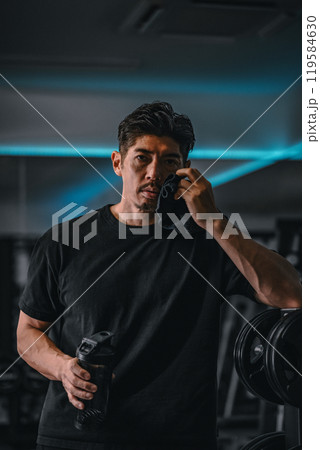 ジムで休憩して水分補給する男性 ジムで休憩して水分補給する男性 119584630