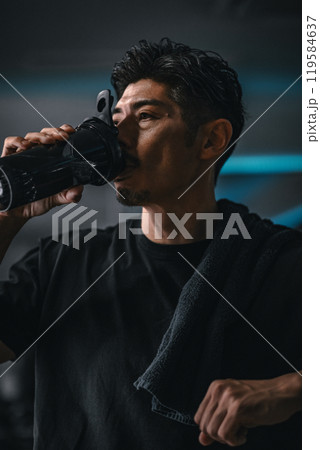 ジムで休憩して水分補給する男性 ジムで休憩して水分補給する男性 119584637