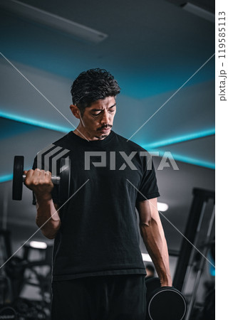 ジムでダンベルトレーニングする男性 119585113