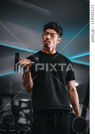 ジムでダンベルトレーニングする男性 119585121