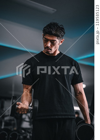 ジムでダンベルトレーニングする男性 119585123