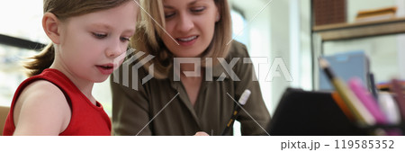 Female teacher explains educational material to schoolgirl 119585352
